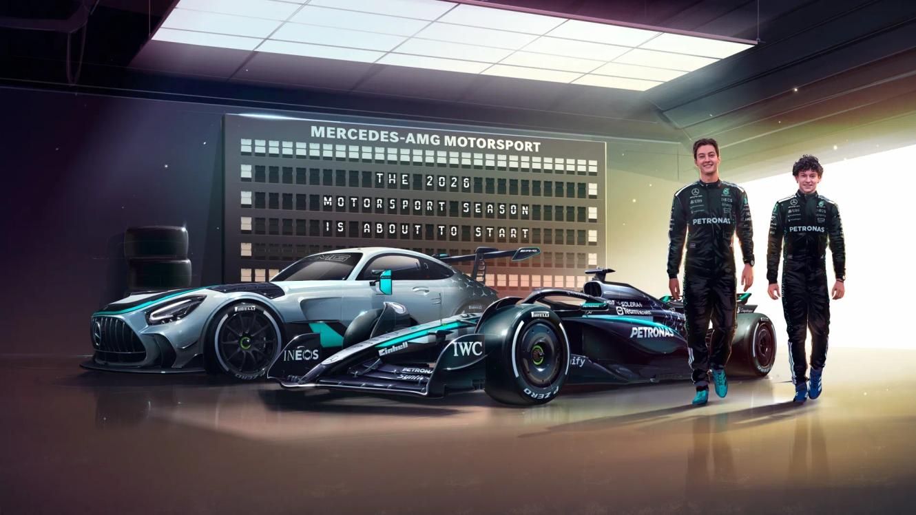 George Russell und Kimi Antonelli stehen in einer Garage neben einem W16 und einem Mercedes-AMG GT2 Edition W16.
