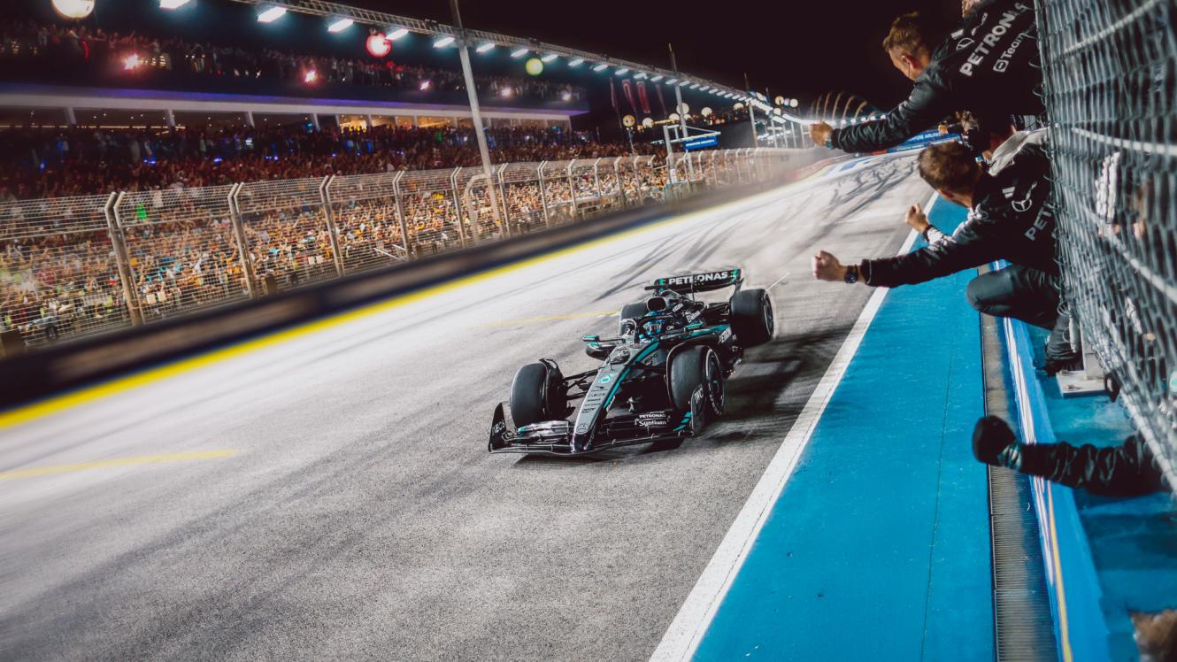 Das Team jubelt George Russell in seinem W16 zu, während er die Ziellinie überquert.