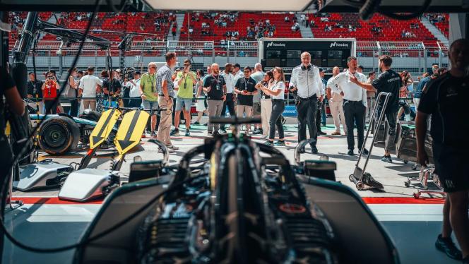 Der W16 steht vor dem Ungarn Grand Prix in der Box, während Besucher durch das offene Tor einen Blick hineinwerfen.