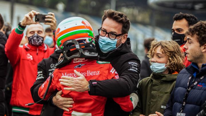 Der Trainer umarmt den Kart-Fahrer