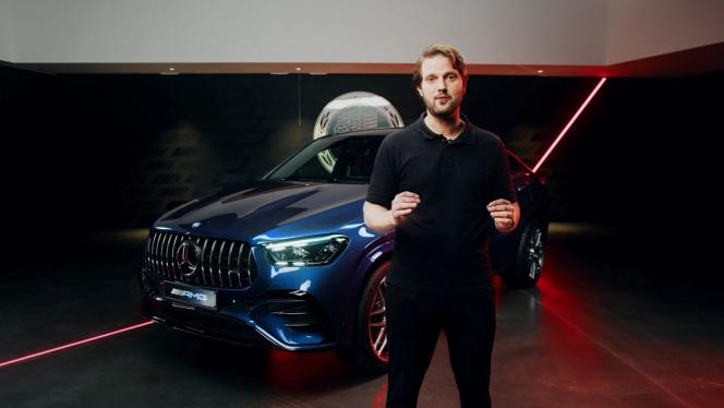 Produktmanager steht in einem Showroom vor dem neuen Mercedes-AMG GLE 53 Coupé