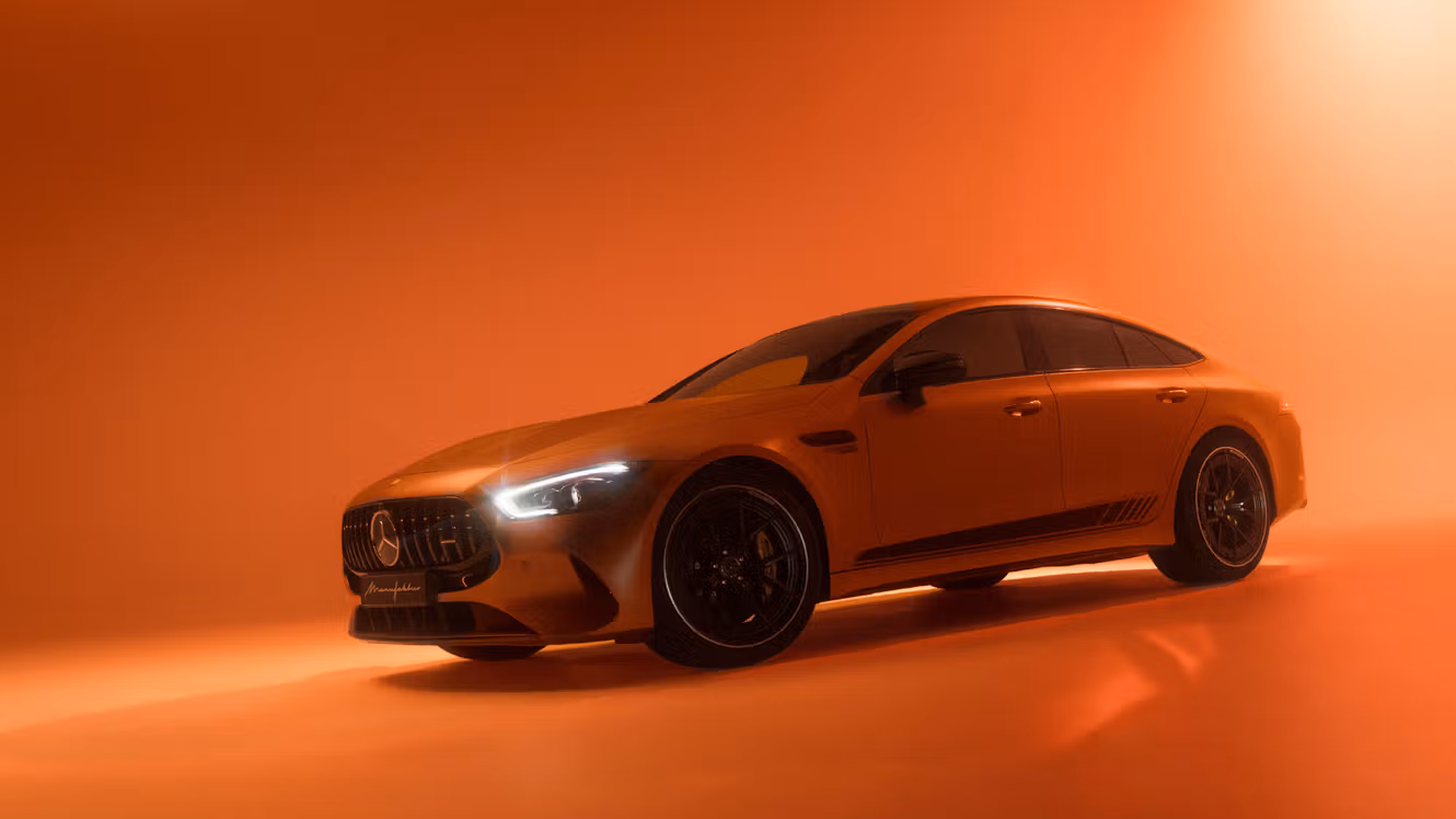 A Mercedes-AMG GT 4 door coupé bathed in orange light.