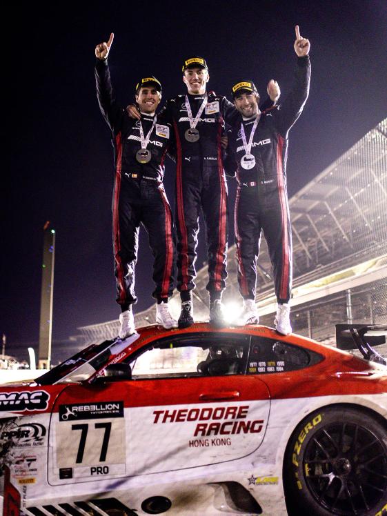 Drivers celebrating on top of a racecar