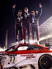 Drivers celebrating on top of a racecar