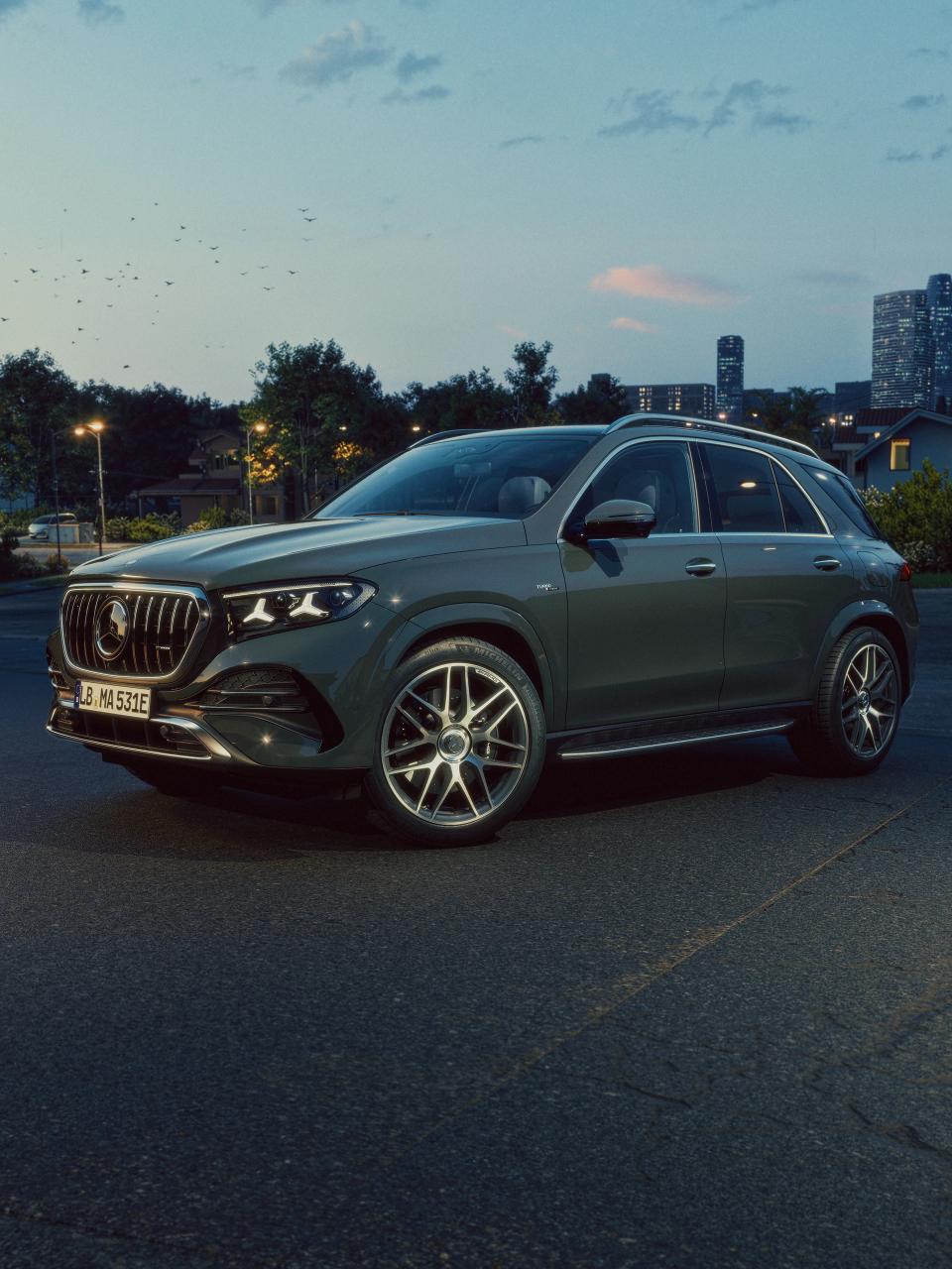 Ein Mercedes-AMG GLE 53 SUV mit einer Stadt im Hintergrund