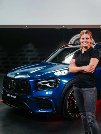 Der blaue Mercedes AMG GLB SUV mit der Produktmanagerin