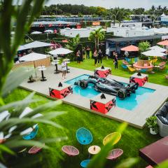 Der W16 steht auf einem Podest in der Mitte einer Grünfläche, umringt von bunten Sonnenschirmen und Sitzgelegenheiten.