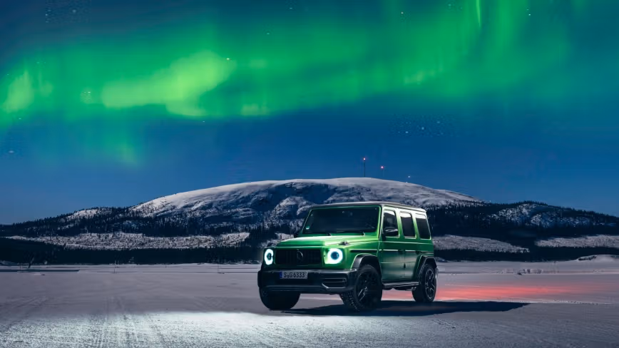 A Mercedes-AMG G-Class with northern lights in the background.