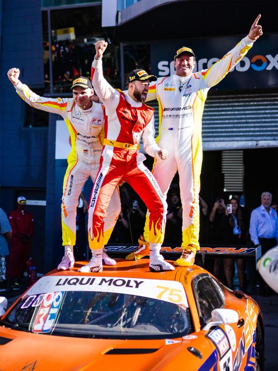 Drei Mercedes-AMG GT Fahrer stehen auf einem Fahrzeug und feiern