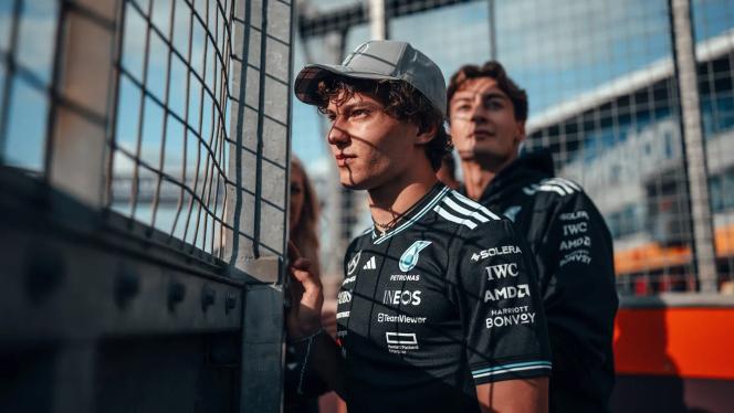 Kimi Antonelli und George Russel stehen während eines Sonnenuntergangs hinter einer Absperrung der Rennstrecke in Silverstone.