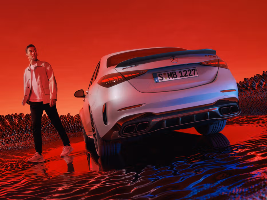 George Russel next to a Mercedes-AMG C 63 S E PERFORMANCE Sedan