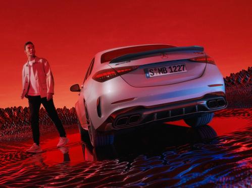 George Russel neben einer Mercedes-AMG C 63 S E PERFORMANCE Limousine