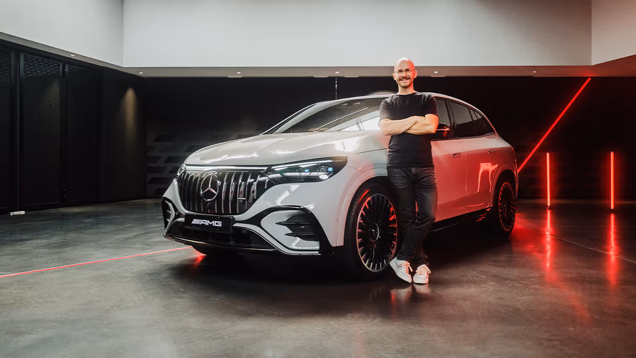 Der Produktmanager steht neben dem Mercedes-AMG EQE 53 4MATIC+ SUV.