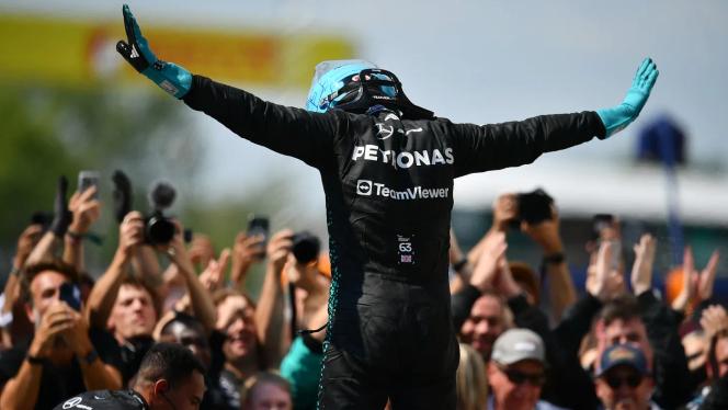 Nach seinem Sieg in Kanada 2025 steht George Russel auf dem W16 und streckt beide Arme von sich