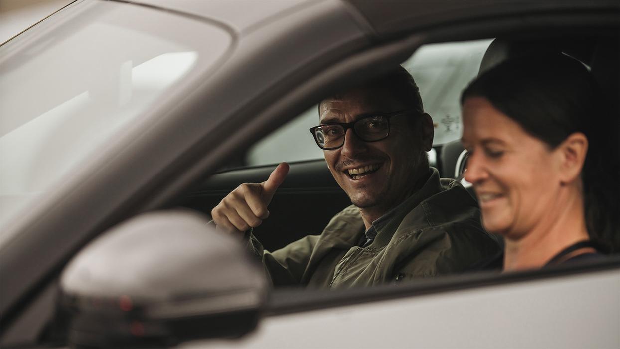 Two people sit in a Mercedes-AMG