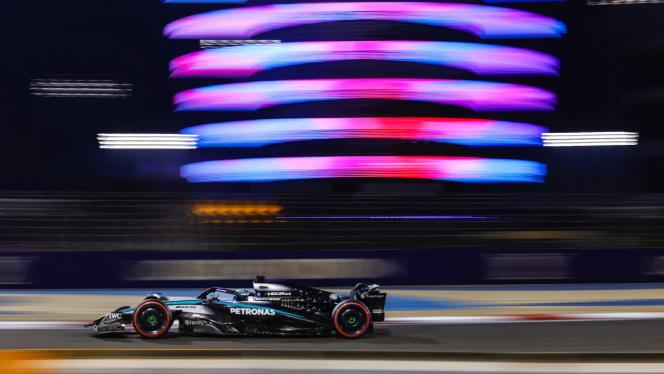 Der W16 fährt am erleuchteten Turm des Bahrain International Circuit vorbei.