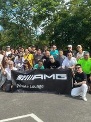 Mitglieder der AMG Private Lounge posieren für ein Gruppenfoto.